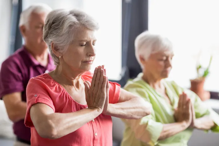 low impact exercise: seniors practicing yoga 