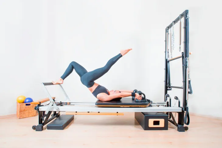 Woman building endurance on a pilates machine 