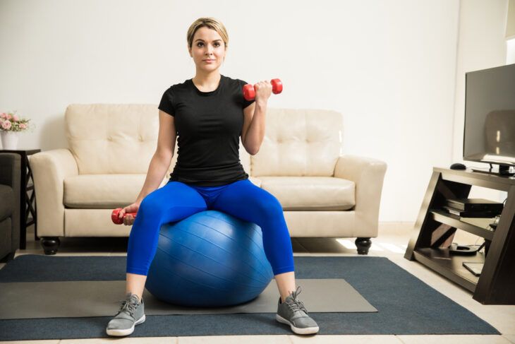 Bicep curls while sitting on a stability ball
